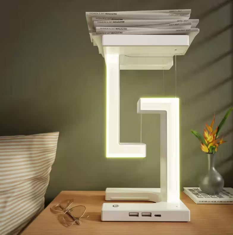 Modern LED table lamp on a bedside table with magazines stacked on top