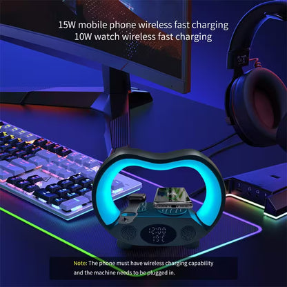 Gaming setup with wireless charging pad, monitor, keyboard, and headphones on a dark surface.