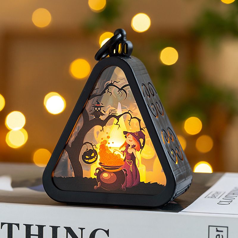 Halloween-themed lantern with a witch and pumpkin design on a blurred background
