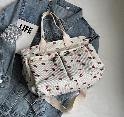 White bag with red floral pattern on a denim jacket