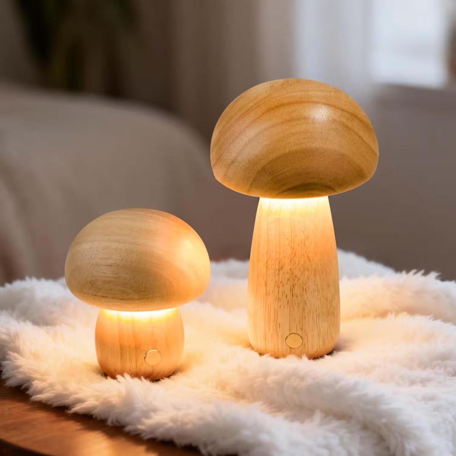 Two wooden mushroom lamps on a soft surface with a blurred background