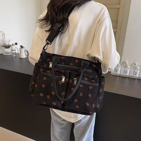 Person holding a black patterned handbag in a kitchen setting