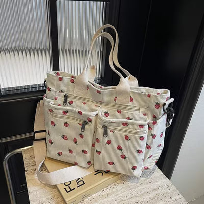 Floral-patterned tote bag with multiple compartments on a surface near a window.